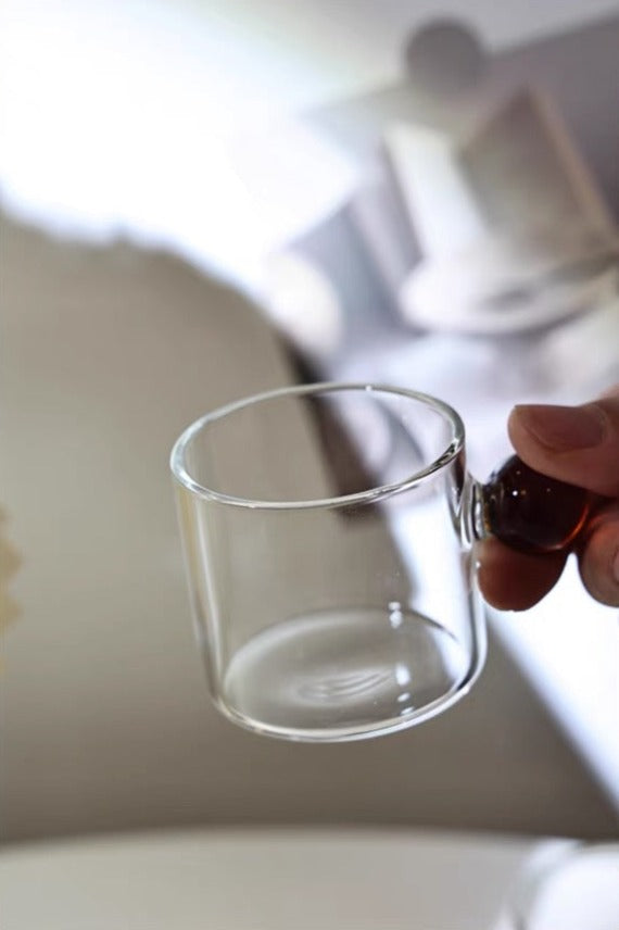 Transparent Glass Cup with a distinctive round ball handle, crafted from high borosilicate heat-resistant glass, showcasing a sleek design with a 5cm height and 5.5cm top diameter, perfect for hot beverages.