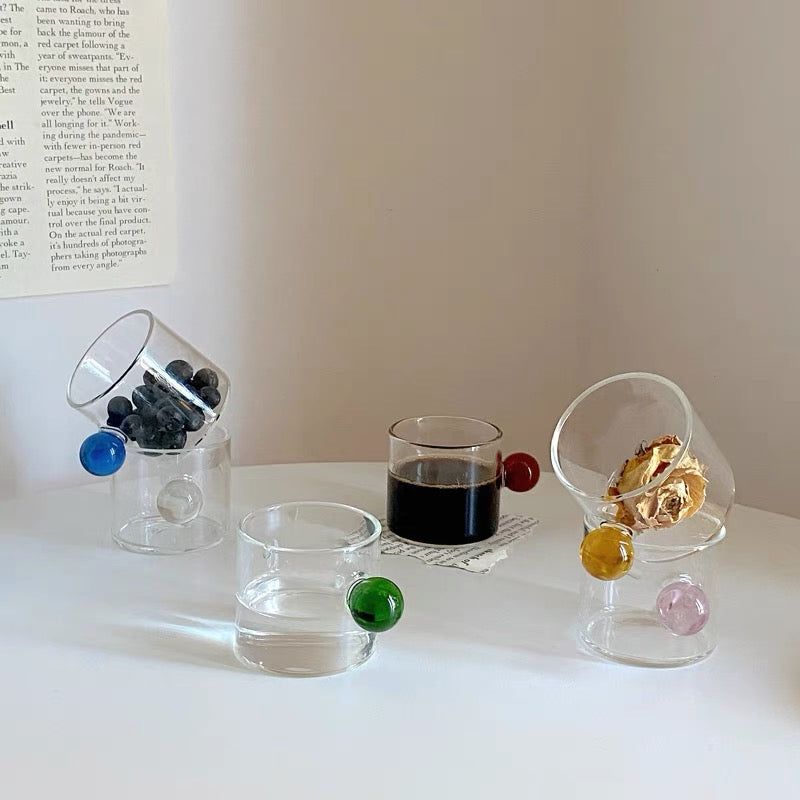Transparent Glass Cup with a distinctive round ball handle, crafted from high borosilicate heat-resistant glass, showcasing a sleek design with a 5cm height and 5.5cm top diameter, perfect for hot beverages.