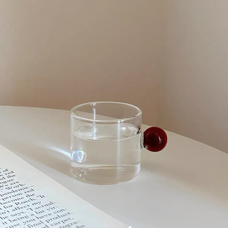 Transparent Glass Cup with a distinctive round ball handle, crafted from high borosilicate heat-resistant glass, showcasing a sleek design with a 5cm height and 5.5cm top diameter, perfect for hot beverages.