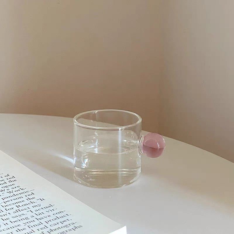 Transparent Glass Cup with a distinctive round ball handle, crafted from high borosilicate heat-resistant glass, showcasing a sleek design with a 5cm height and 5.5cm top diameter, perfect for hot beverages.