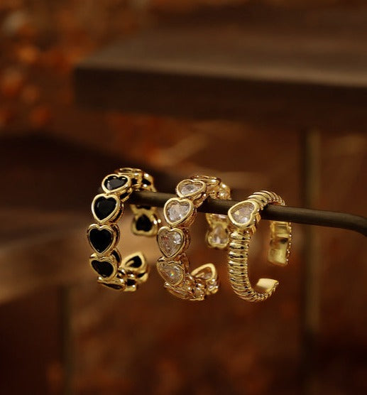 18k gold-plated openwork brass ring showcasing a heart-shaped zircon stone, with contrasting gold and black tones and an open-mouth design.