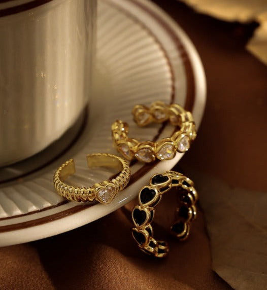 18k gold-plated openwork brass ring showcasing a heart-shaped zircon stone, with contrasting gold and black tones and an open-mouth design.