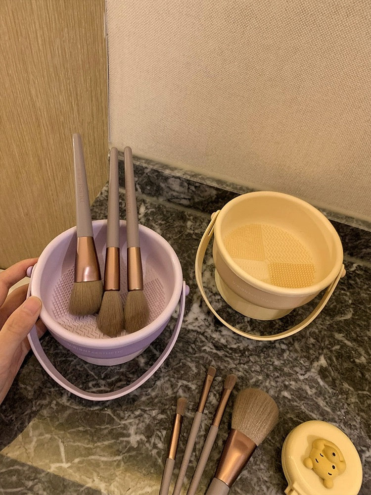 "Silicone Makeup Brush Cleaning and Storage Bowl - High-quality silicone material with elastic mesh and hanging strap for thorough brush cleansing. Dimensions: 14.5 x 13 x 8cm."