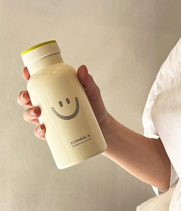 Yellow Smiley Face Thermal Bottle with a stainless steel inner lining, designed to keep beverages hot or cold. Iconic smiley face emblem prominently displayed on the front.