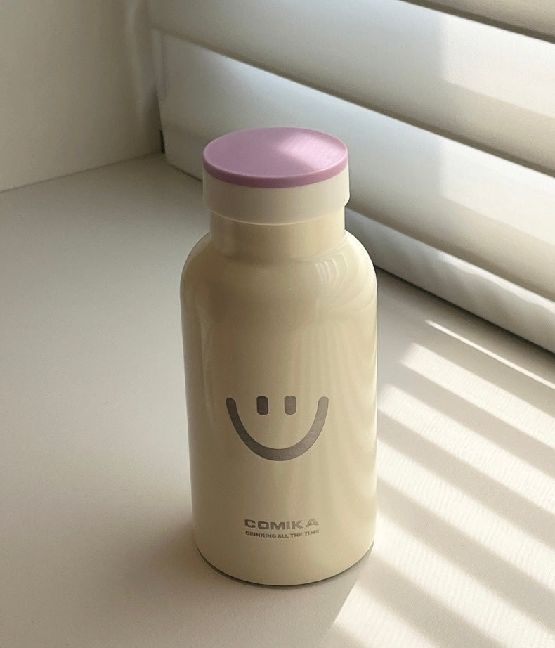 Yellow Smiley Face Thermal Bottle with a stainless steel inner lining, designed to keep beverages hot or cold. Iconic smiley face emblem prominently displayed on the front.