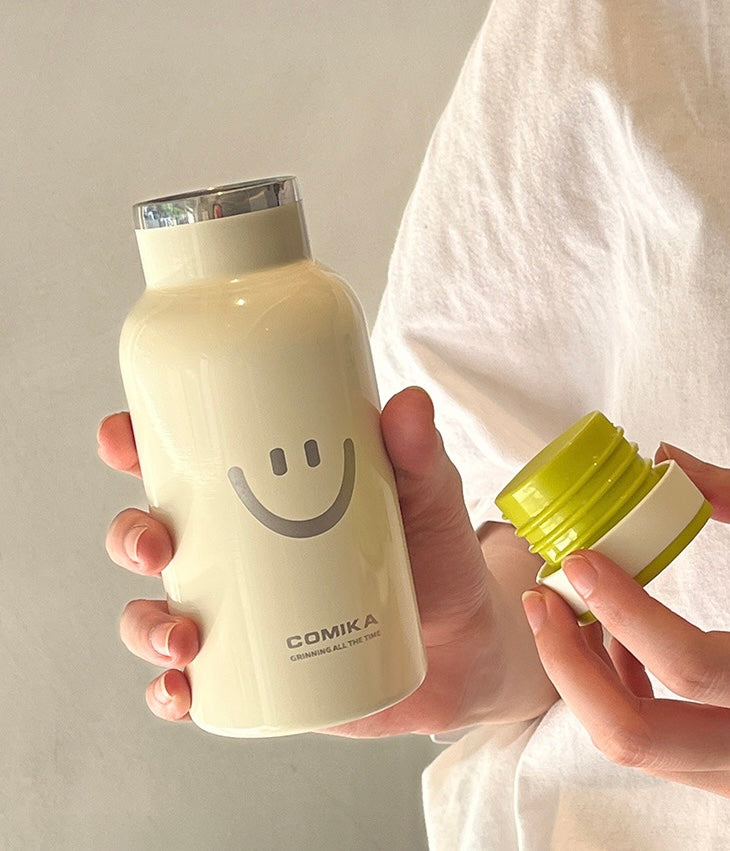Yellow Smiley Face Thermal Bottle with a stainless steel inner lining, designed to keep beverages hot or cold. Iconic smiley face emblem prominently displayed on the front.