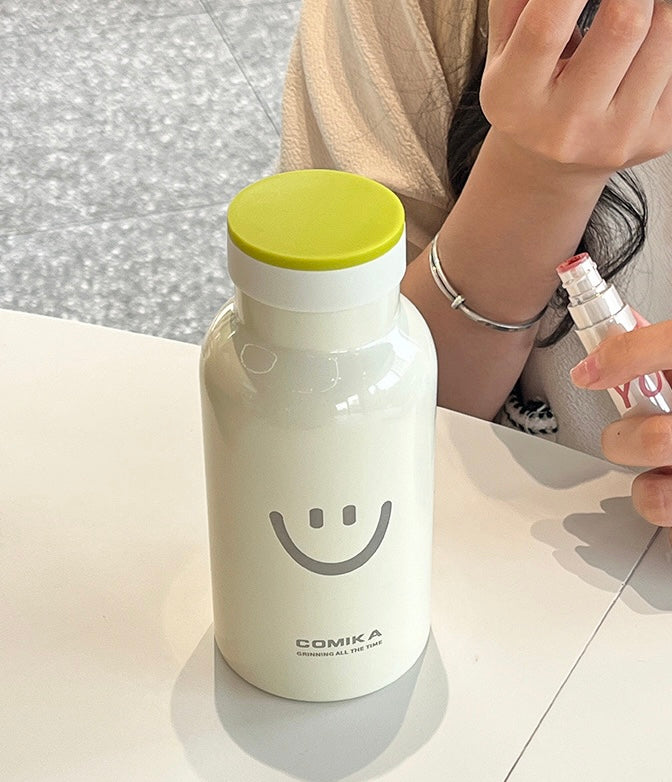 Yellow Smiley Face Thermal Bottle with a stainless steel inner lining, designed to keep beverages hot or cold. Iconic smiley face emblem prominently displayed on the front.
