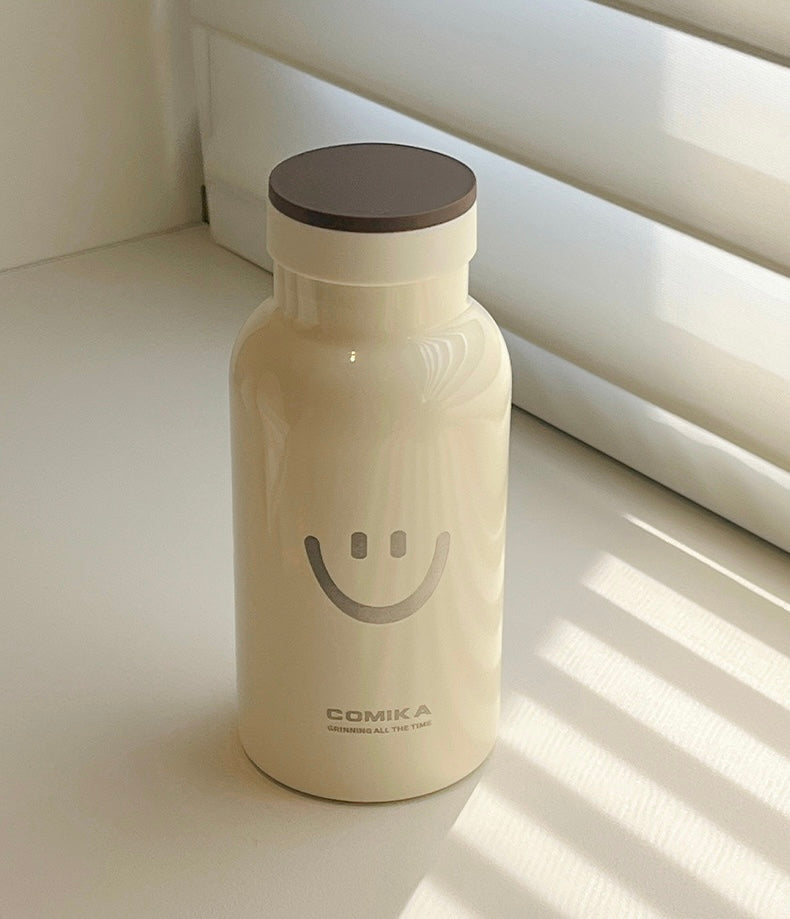 Yellow Smiley Face Thermal Bottle with a stainless steel inner lining, designed to keep beverages hot or cold. Iconic smiley face emblem prominently displayed on the front.