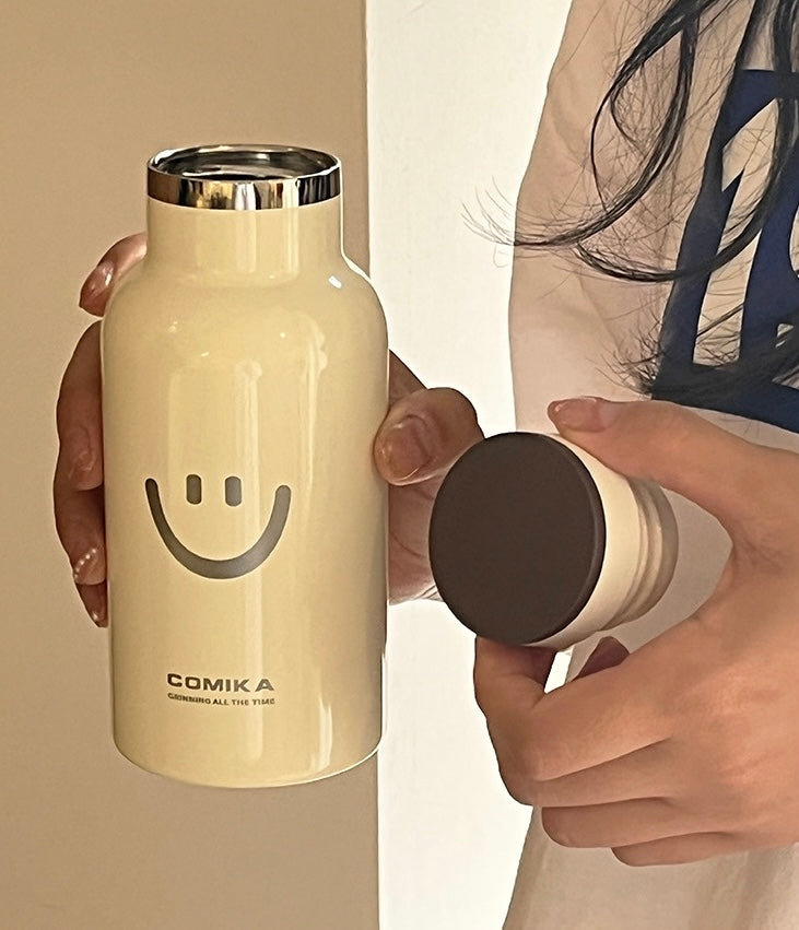 Yellow Smiley Face Thermal Bottle with a stainless steel inner lining, designed to keep beverages hot or cold. Iconic smiley face emblem prominently displayed on the front.