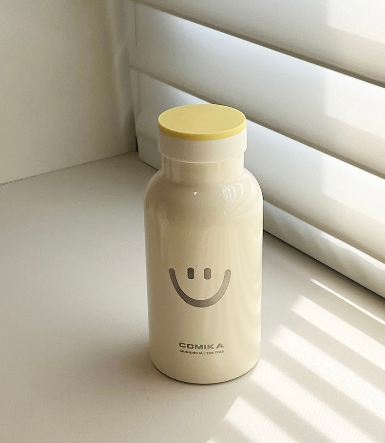 Yellow Smiley Face Thermal Bottle with a stainless steel inner lining, designed to keep beverages hot or cold. Iconic smiley face emblem prominently displayed on the front.