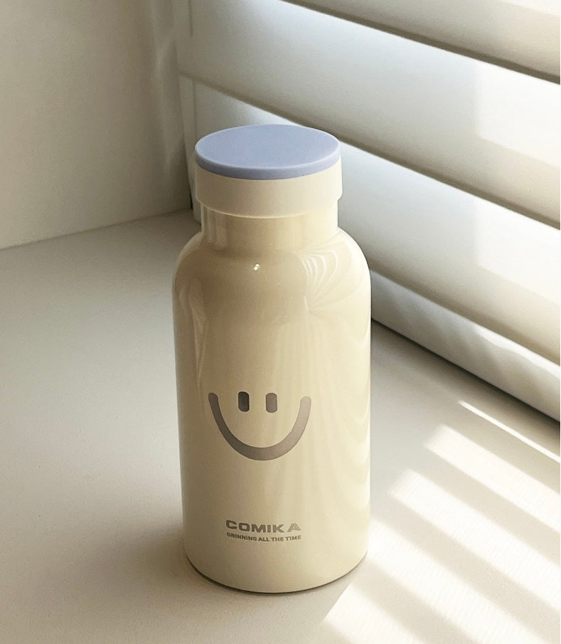 Yellow Smiley Face Thermal Bottle with a stainless steel inner lining, designed to keep beverages hot or cold. Iconic smiley face emblem prominently displayed on the front.