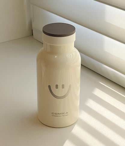 Yellow Smiley Face Thermal Bottle with a stainless steel inner lining, designed to keep beverages hot or cold. Iconic smiley face emblem prominently displayed on the front.